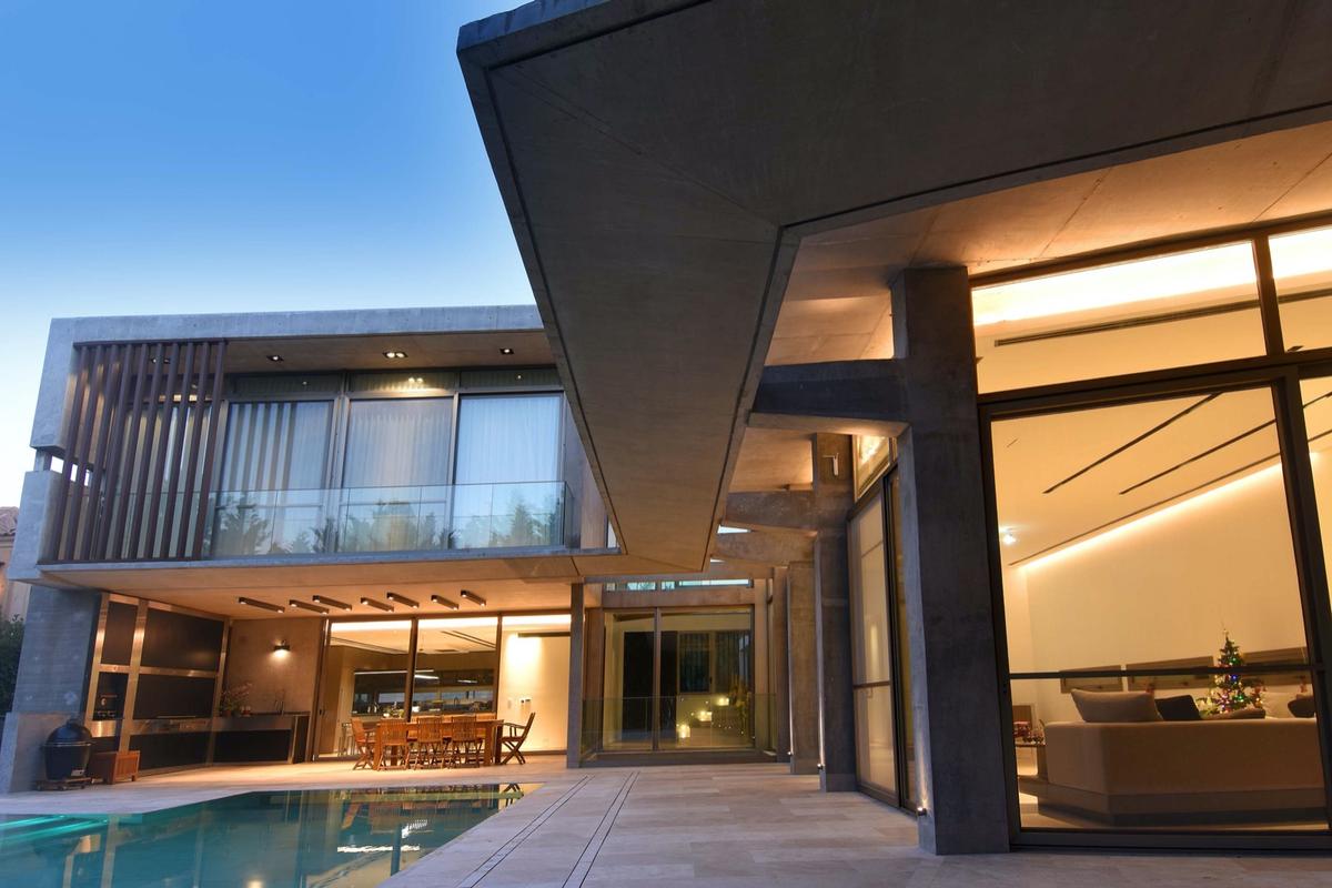 Fachada moderna em concreto aparente e piscina, estilo brutalista — projeto Casa Wellness, por Santiago Cordeyro Arquitectos, em San Isidro